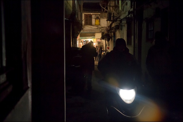 Motoring through an alley, Shanghai, China.