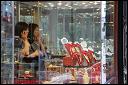 Woman on telephone, jewelry shop window on Canal Street. Chinatown, NYC.