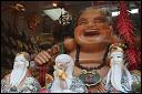 Smiling porcelain buddha and wise men in shop window. Chinatown, NYC.