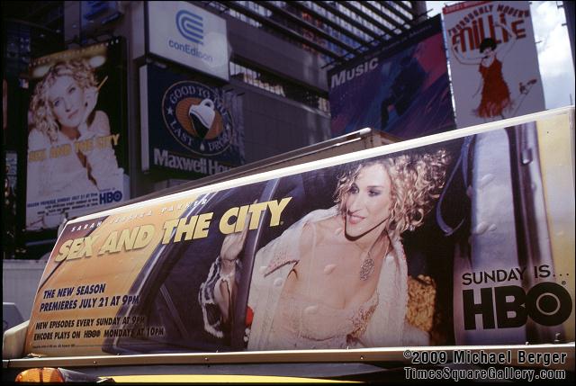Billboard and ad on top of a taxi driving through Times Square. 2002.