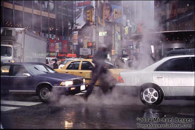 Crossing W. 44th St. and Broadway during a heavy summer rain in Times Square. 2002.
