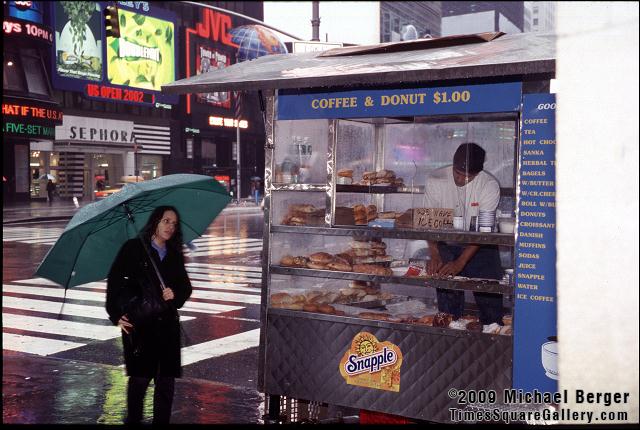Purchasing morning coffee on W. 44th St. and 7th Ave in the rain. 2002.