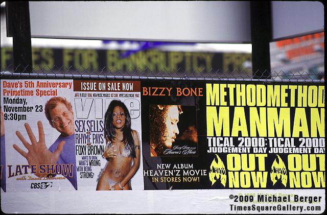 Posters on parking lot fence on West 41st Street off 7th Avenue with 1 Times Square zipper. 1998.