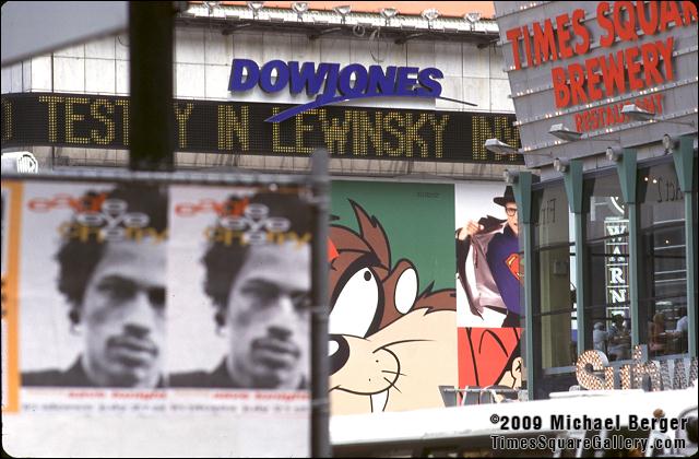 Posters on parking lot fence on West 41st Street off 7th Avenue with 1 Times Square zipper. 1998.
